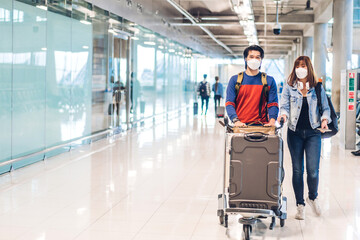 Young happy couple traveler in quarantine for coronavirus wearing surgical mask face protection...