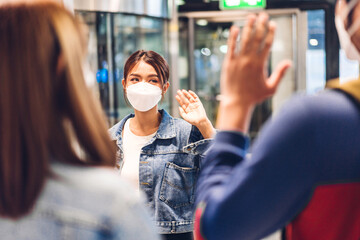 Young couple traveler in quarantine for coronavirus wearing surgical mask face protection waving hi...