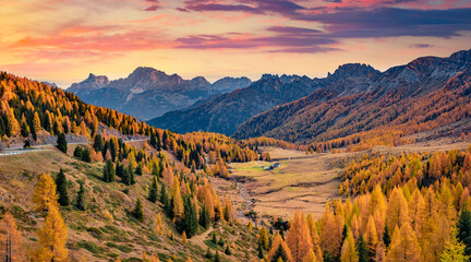 Colorful autumn view of Valles valley. Colorful sunrise in Dolomite Alps with jagged peaks, rolling meadows, pastures and streams. Stunning morning scene of Italian countryside.