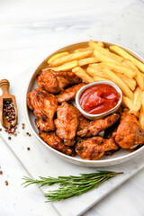 Lunch fast food chicken wings with ketchup and potatoes fries	
