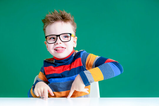 The gamine boy in glasses shows tongue. Close-up