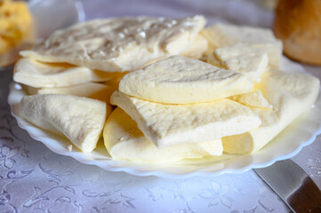 Cheese on a plate in restaurant. Delicious young cheese prepared for breakfast, close up.