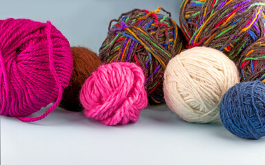 Fototapeta na wymiar Heap of colorful woolen yarn balls on blue wooden background
