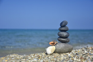 Balanced stone pyramid on sand on beach. Zen rock, concept of balance and harmony