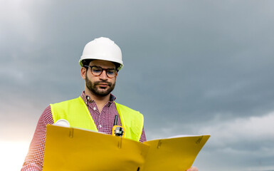 Male contractor reading documents near solar farm