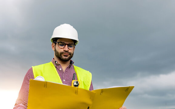 Male contractor reading documents near solar farm