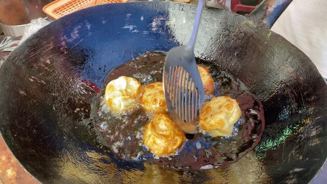 Nepalese traditional dumpling Momo fried in hot oil in local market in India