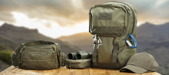 Green bag and backpack and landscape of mountains. 