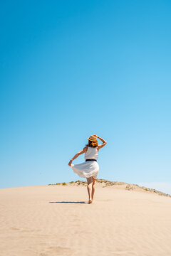 Smiling Woman In Dress Walking On Sandy Beach In Summer