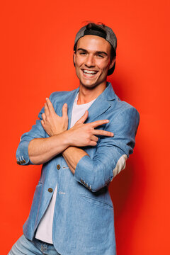 Stylish man with cap on red background
