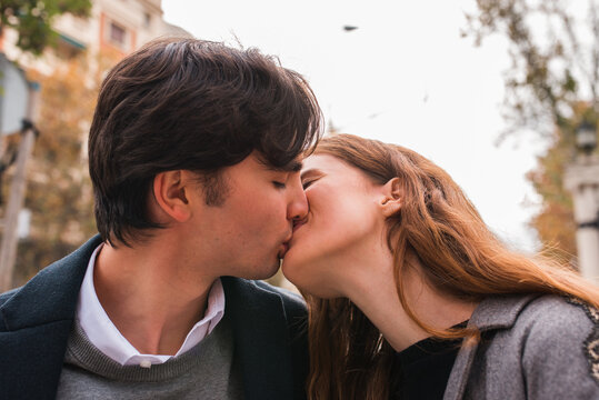 Young couple in love kissing on street