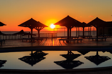 Luxury swimming pool with sea view at sunrise. Concept of rest, relaxation, holidays, resort