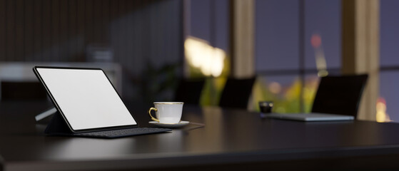 Digital tablet mockup and coffee cup on modern dark meeting table in the meeting room. close-up