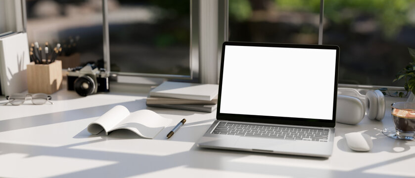 A modern office workspace tabletop against the window with notebook laptop mockup.