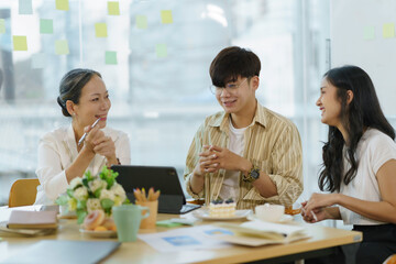 Group of Asian business people meeting, consulting and planning business on investment and market analysis for business development there are various analytical data document and using a laptop.