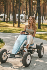 Young woman riding quadrocycle and looking excited