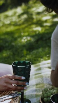 a close up of a man pouring a drink of water at a picnic