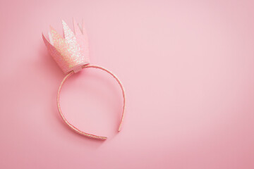 Pink princess crown headband for girls on pink background. Festive girlie feminine birthday party...
