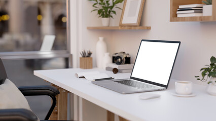 Notebook laptop mockup is on a modern white office desk with decor accessories. close-up