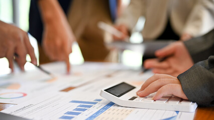 A female accountant using a calculator during the meeting with her team. cropped image