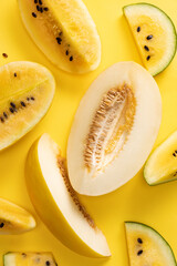 Top view of ripe fresh yellow melon, slices over bright yellow background. Design for wallpaper, greeting season card. Sweet and healthy. Monochrome