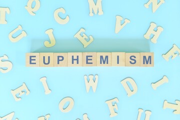 Euphemism figure of speech concept in English grammar class lesson. Wooden blocks typography flat lay in blue background.