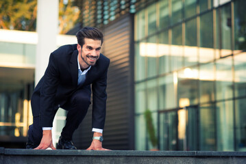 Young smiling businessman ready for race start