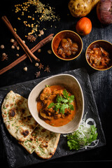 Chicken tikka masala spicy curry meat food Butter chicken with rice and naan bread on dark background close-up