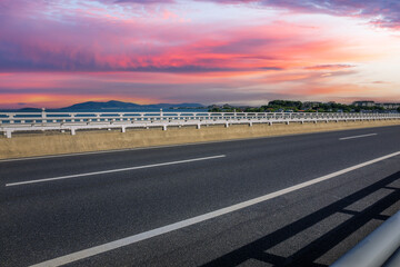 Asphalt highway and beautiful coastline nature landscape at sunset