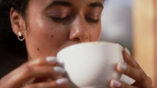 A  close up of happy latino woman enjoying a coffee