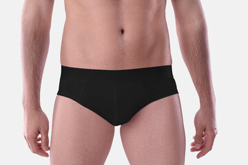 Mockup of black underpants on a guy, tight brief underwear on a shaved body, close-up, isolated on...