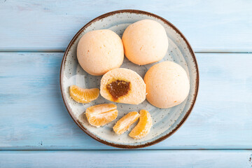 Japanese rice sweet buns mochi filled with tangerine jam on a blue wooden. top view.