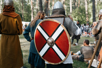 Knights of war preparing for battle in forest outdoors. Back view of viking in helmet, chain mail...