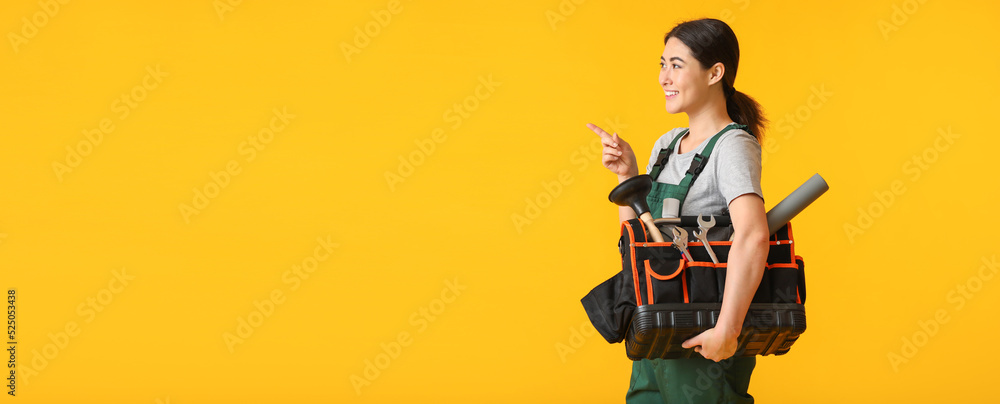 Poster female plumber with tools bag pointing at something on yellow background with space for text