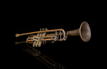 Playing jazz music on vintage trumpet with black refection background