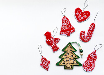 New Year and Christmas hand made red and green decorations made of wood and felt fabric on white paper. Flat lay, copy space