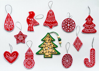 New Year and Christmas hand made red and green decorations made of wood and felt fabric on white paper. Flat lay, retro style
