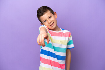Little boy isolated on purple background pointing front with happy expression
