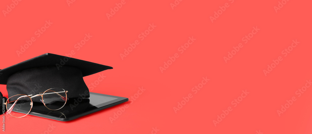 Wall mural graduation hat with tablet computer and eyeglasses on red background with space for text