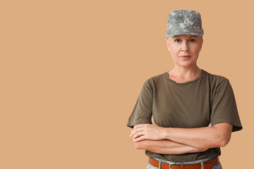 Mature female soldier on beige background