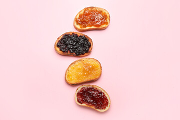 Toasts with different jams on pink background