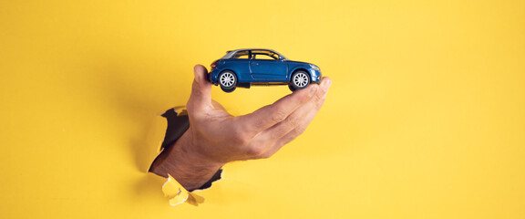 Small yellow car covered by hands