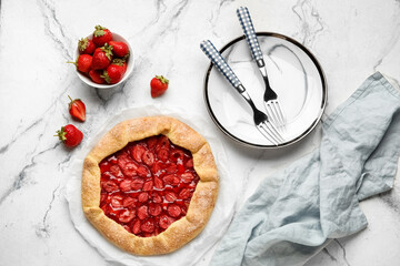 Composition with tasty strawberry galette, fresh berries and plate on light background