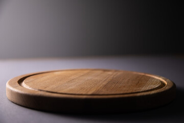 Empty round pizza board on table