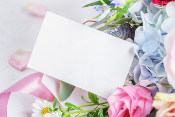 Paper card mockup on flower bouquet with pink ribbon