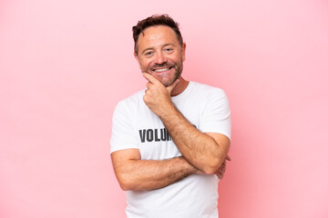 Middle age volunteer man isolated on pink background isolated on pink background happy and smiling