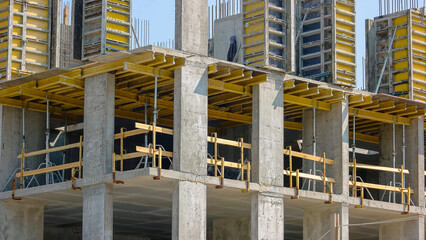 Unfinised building skyscraper construction with metal framework. Blue sky background.