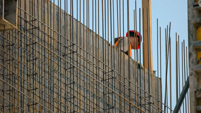 Worker on the skyscraper builiding construction site. Blue sky background.