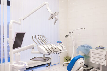 Interior of dental equipment in dentist room in new modern stomatological clinic office. Background of dental chair and accessories used by dentists in blue color. Copy space, text place
