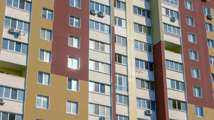 Fototapeta premium Multicolored high-rise apartment house for background. Ugly buildong in a dormitory area.
